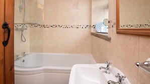 A bathroom with a bathtub, a sink, a mirror, and a shower. - 3 Bed in Buxton (oc-pk656) (Blackwell)