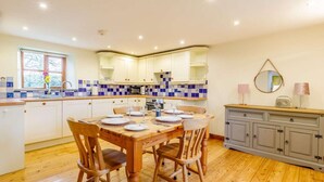 A kitchen with a dining table set for four, wooden chairs, and a grey cabinet with drawers. - 2 Bed in Holsworthy (oc-gmead) (Holsworthy Hamlets)