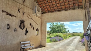 A rustic interior with a bench, wall-mounted decorations, and a view of a rural road outside. - Two charming vacation rentals in a beautiful setting, accommodating up to 12 people (Clévilliers)