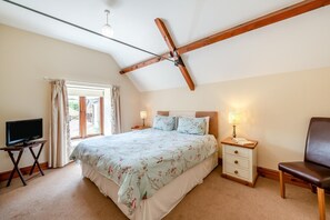 A bedroom with a bed, bedside tables, a chair, a television, and a window with curtains. - 4 Bed in Watchet (oc-huisb) (Beggearn Huish)