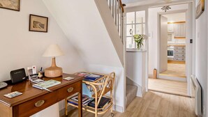 A room with a desk, lamp, chair, and a staircase leading to another room. - 3 Bed in Niton Undercliff (oc-ic125) (Niton)