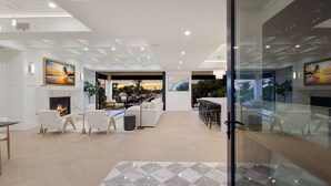 A modern interior with a fireplace, seating area, and artwork on the walls. - Sunset Tulia Paradise (Anna Maria)