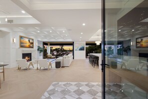 A modern interior with a fireplace, seating area, and artwork on the walls. - Sunset Tulia Paradise (Anna Maria)