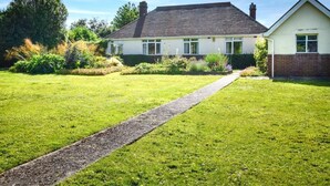 Une maison de plain-pied avec une allée pavée menant à l’entrée.