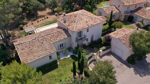 Un quartier résidentiel composé de plusieurs maisons, chacune dotée d’un toit en tuiles et entourée de verdure.