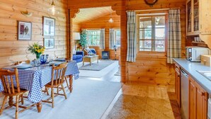 Ein Holzblockhaus-Interieur mit Essbereich, Küche und Wohnbereich.