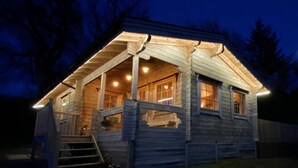 Eine Holzhütte mit Veranda, Treppe und kleinem Fenster.