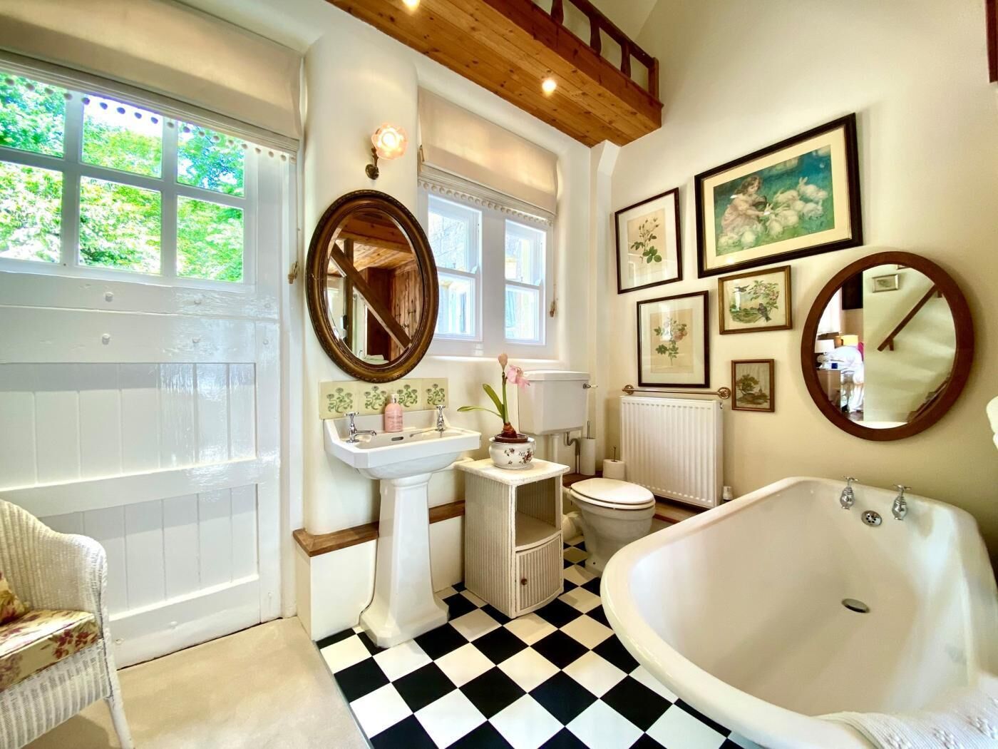Une salle de bain avec un carrelage à motifs, une baignoire, un lavabo, des toilettes et un miroir.