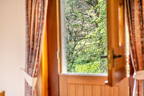 Ein Zimmer mit Holztür und einem fensterbehangenen Fenster.