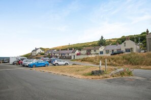 Eine Küstenstraße mit parkenden Autos und Häusern.