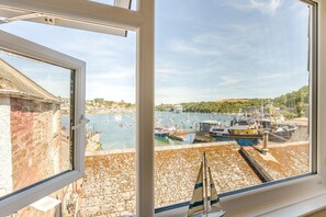 A view from a window overlooking a harbor with boats and a ship docked. - 2 Bed in Polruan (oc-pc023) (Fowey)