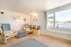 A cozy room with two armchairs, a small table, and a view of the sea. - 2 Bed in Polruan (oc-pc023) (Fowey)