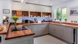 A modern kitchen with wooden countertops, built-in cabinets, and a window providing natural light.