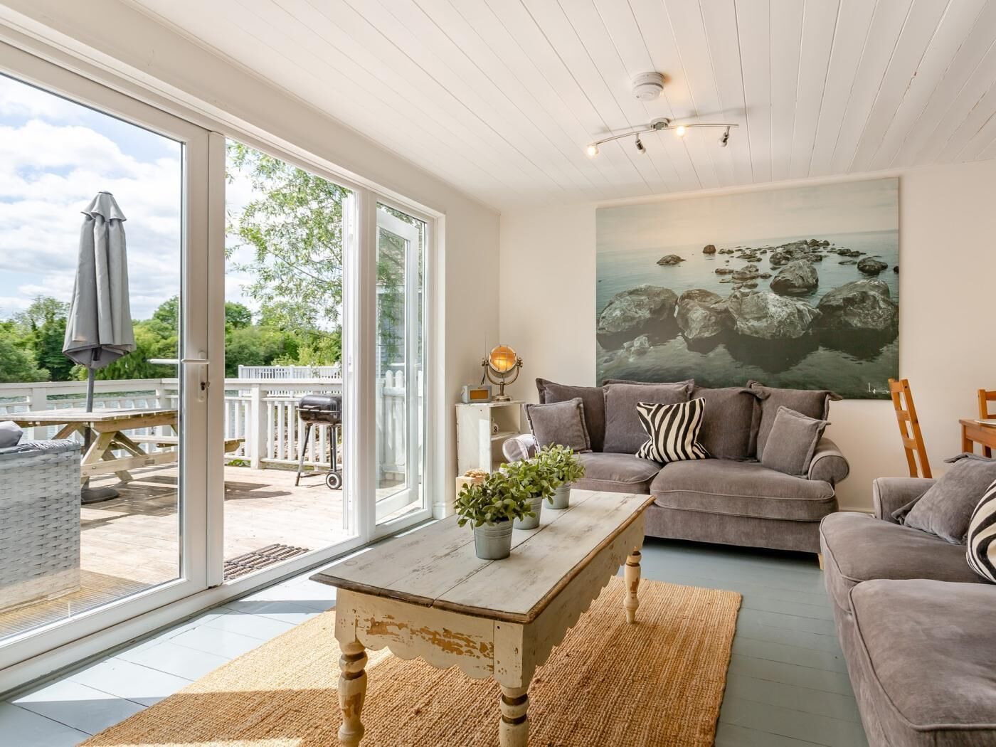 A living room with a sofa, a coffee table, and a painting on the wall.