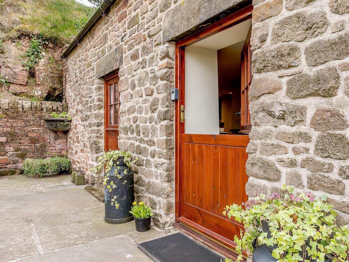 Un bâtiment en pierre avec une porte et des fenêtres en bois.