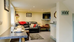 A compact living space with a dining area, a sofa, a television, and a fireplace. - 1 Bed in Matlock (oc-61938) (Tansley)