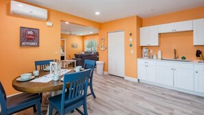 Un espace de vie compact comprenant un coin repas, une kitchenette et un placard visible.