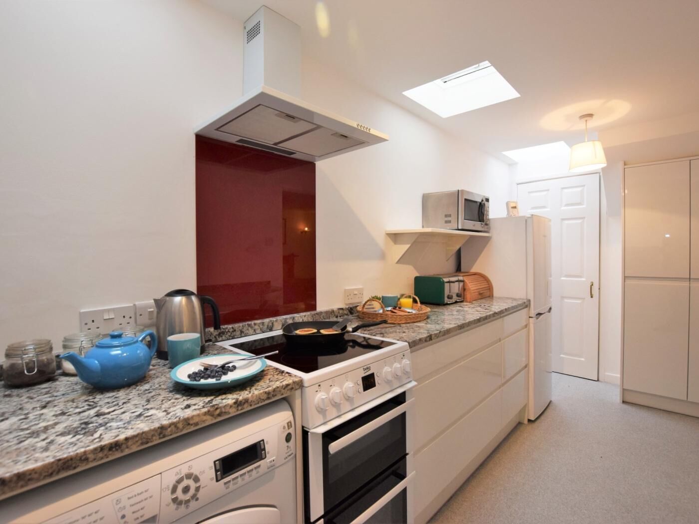 A compact kitchen with a microwave, toaster, and stove.