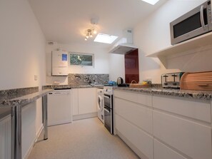 A compact kitchen with a dishwasher, oven, microwave, and a toaster. - 3 Bed in Fowey (oc-pc008) (Fowey)