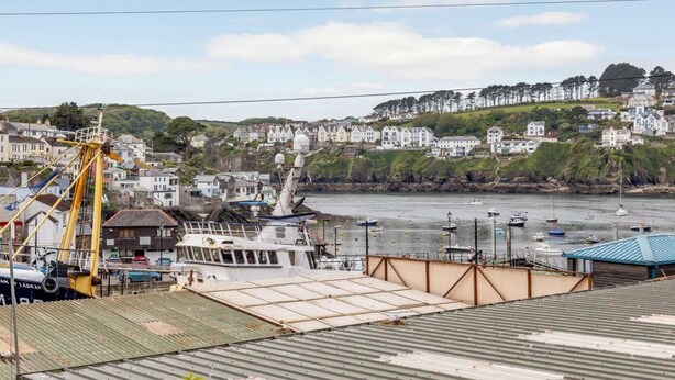 A coastal town with a dock, boats, and houses along the hillside. - 2 Bed in Polruan (oc-pc021) (Fowey)