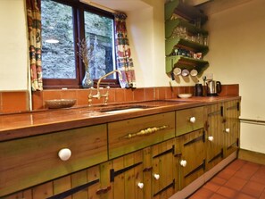 A kitchen with a wooden countertop, a sink, and a window with curtains. - 3 Bed in Polruan (oc-pc032) (Fowey)