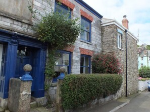 A stone building with blue doors and windows, a hedge, and a brick chimney. - 3 Bed in Polruan (oc-pc032) (Fowey)