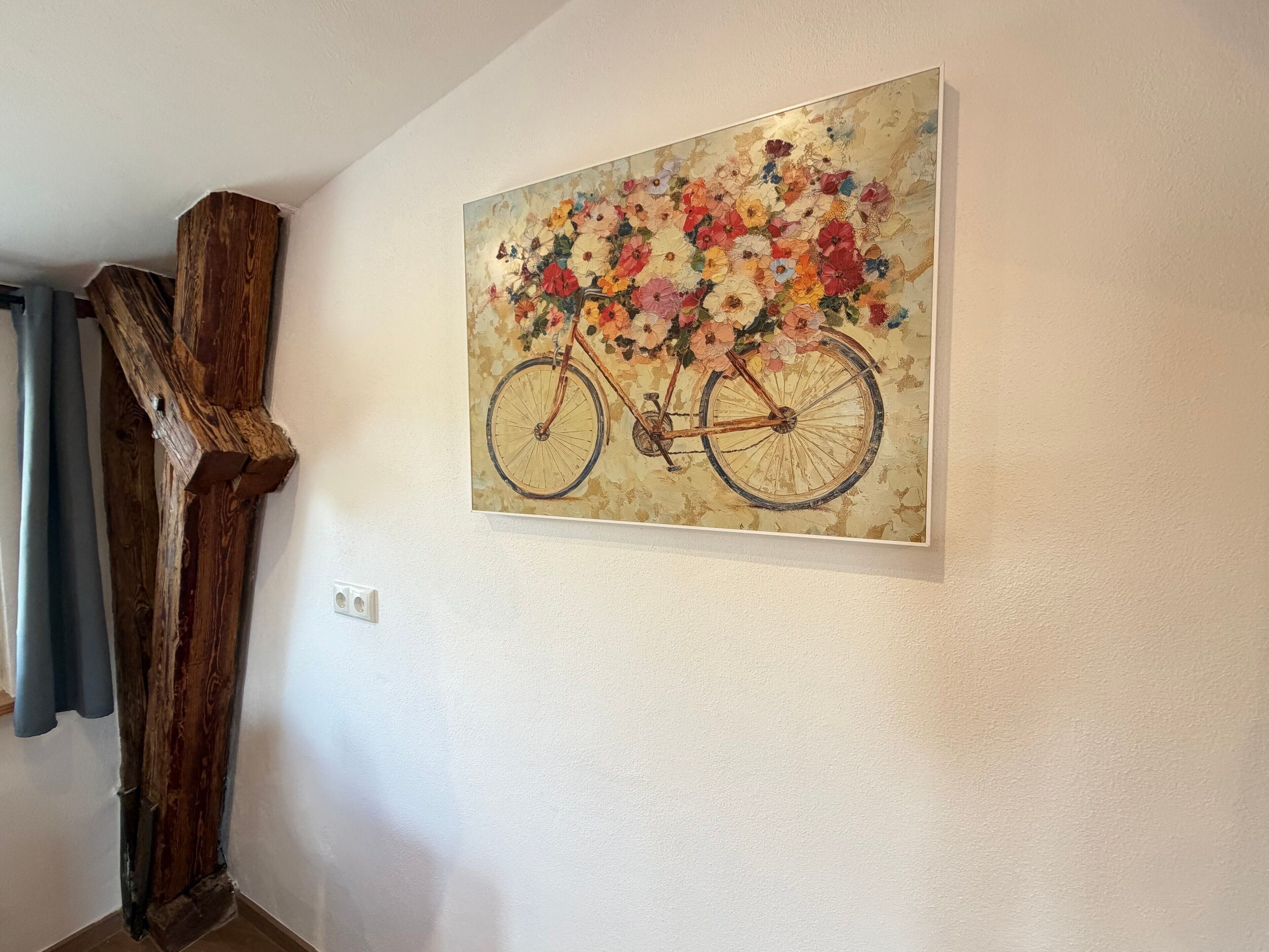 A painting of a bicycle with flowers on the wall.