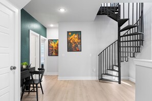 A modern interior with a staircase, a dining area, and artwork on the walls. - SA's Best Downtown Location - Terrace, Jazz Themed (San Antonio)