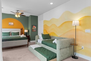 A hotel room with a bed, a sofa, a standing lamp, and a ceiling fan. - SA's Best Downtown Location - Terrace, Jazz Themed (San Antonio)
