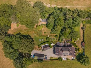 An aerial view of a residential area with multiple houses, a large central building, and surrounding greenery. - 1 Bed in Barnstaple (oc-62134) (Swimbridge)