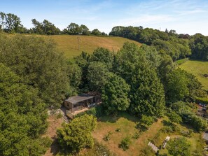 A secluded house surrounded by dense forest, with a clear view of the surrounding landscape.