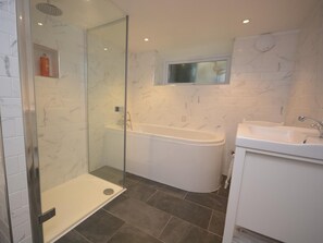 A modern bathroom with a glass-enclosed shower, a freestanding bathtub, and a sink with a mirror above it. - 3 Bed in Polruan (oc-pc012) (Polruan)