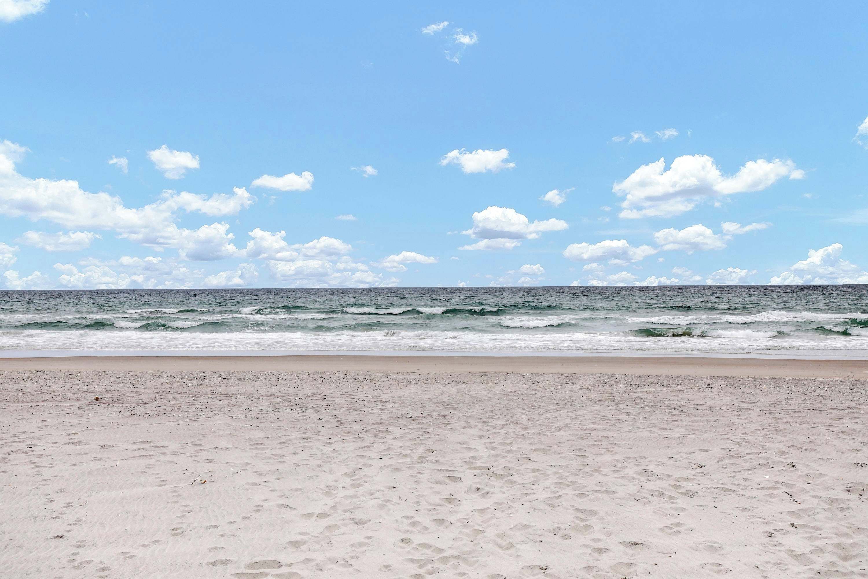 A beach with a clear sky and ocean waves.