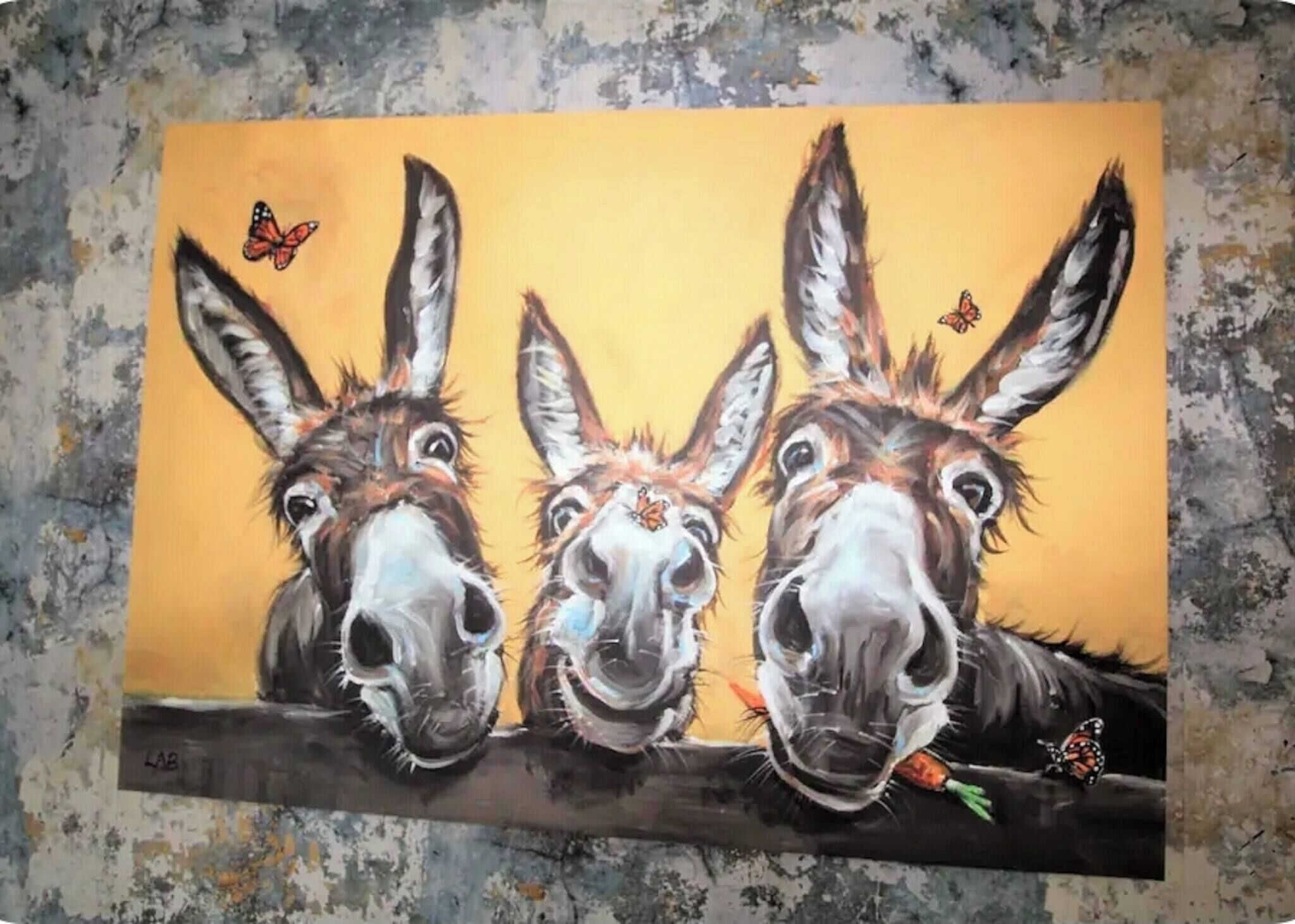 A painting of three donkeys on a branch with a yellow background.