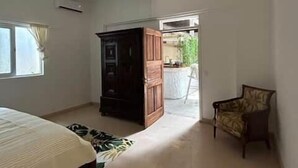 A bedroom with a bed, a wardrobe, a chair, and a ceiling fan. - Private Apartment in the Heart of Downtown Marigot (Marigot)