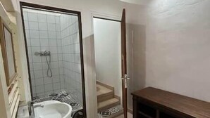 A bathroom with a sink, mirror, and shower. - Private Apartment in the Heart of Downtown Marigot (Marigot)