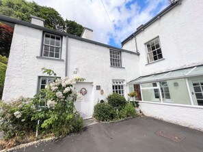 A white building with a central door, windows, and a covered porch area. - 3 Bed in Ambleside (oc-62587) (Claife)