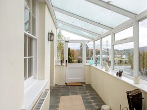 A conservatory with a door, stone flooring, and a view of the outside. - 3 Bed in Ambleside (oc-62587) (Claife)