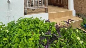 Un bâtiment doté d’un porche, d’un escalier et d’une balustrade en bois.