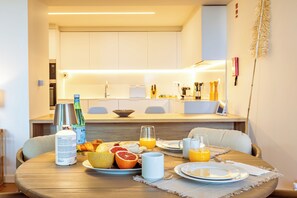 A breakfast table set with plates, glasses, and a variety of food items. - One-bedroom apartment in Bayline, Armação de Pêra, for a maximum of 2 guests. Includes AC, Wi-Fi, equipped kitchen, private parking, pool, spa and gym. Short walk to the beach and promenade. (Armação de Pêra)