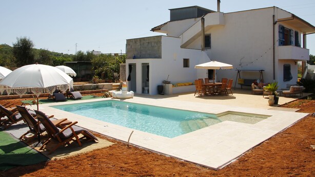 A modern house with a swimming pool, outdoor furniture, and a patio area. - Room-casa Allegria, Camera Felicità - ad (Parabita)