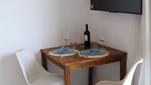 A dining table with two chairs, a bottle of wine, and two wine glasses. - Room-casa Allegria, Camera Felicità - ad (Parabita)