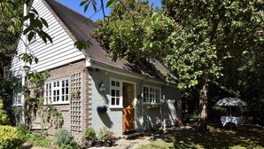 Une maison avec une façade en briques, un revêtement extérieur blanc et une porte d’entrée.