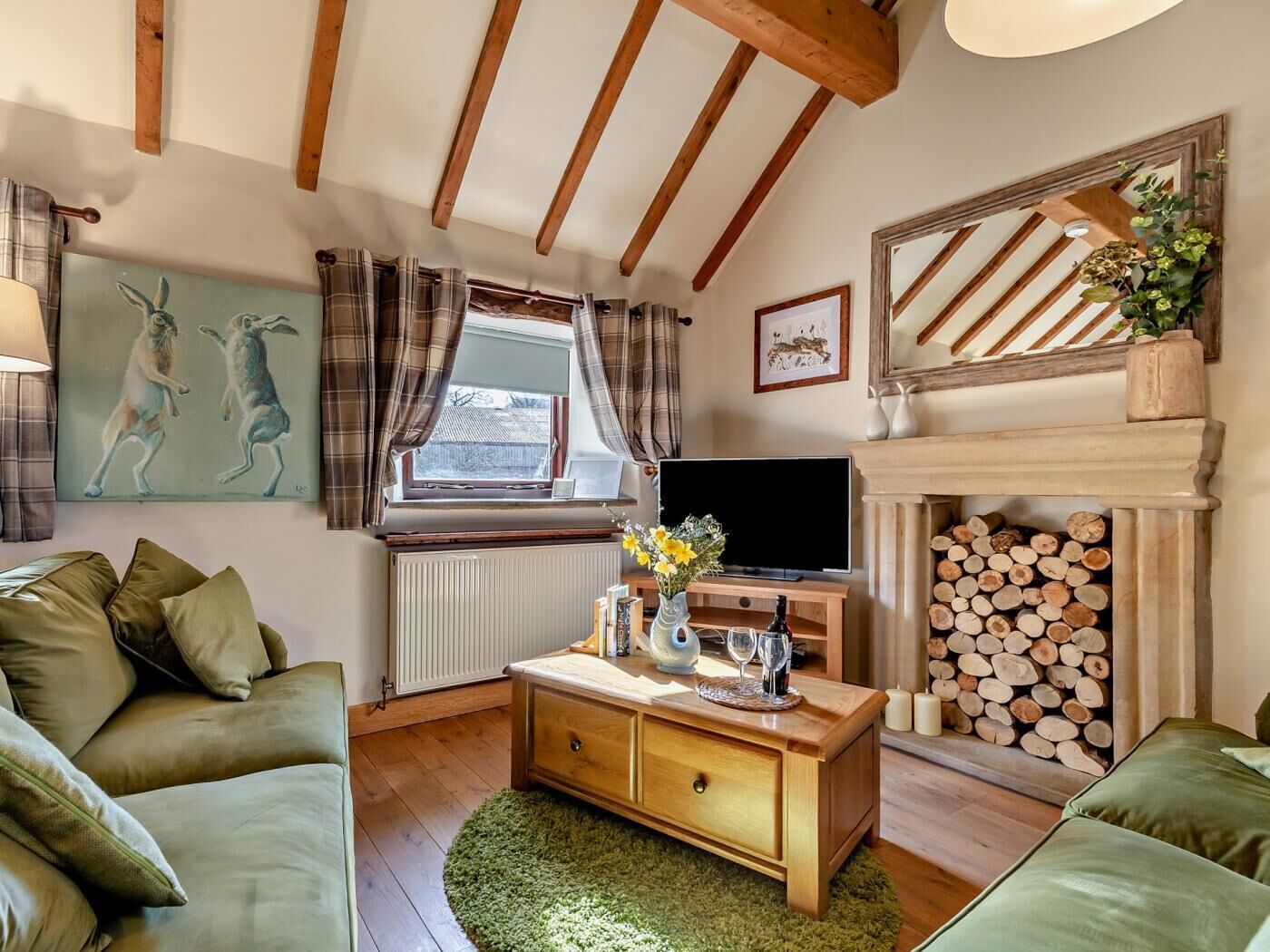 A cozy living room with a fireplace, a television, and a comfortable sofa.