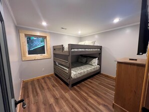 A room with a bunk bed, a wooden cabinet, a window with a view, and recessed ceiling lights. - Escape to Firefly Ridge in Sevierville and discover your perfect Tennessee mount (Sevierville)