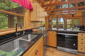 Prepare meals in your fully equipped kitchen with gleaming granite counters, stainless steel appliances, and sweeping forest views through floor-to-ceiling windows that bring the outdoors in. - Escape to Firefly Ridge in Sevierville and discover your perfect Tennessee mount (Sevierville)