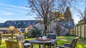 A wooden deck with a table and chairs, a wooden fence, and a barn in the background. - 2 Bed in Beaminster (oc-63047) (Littlewindsor)