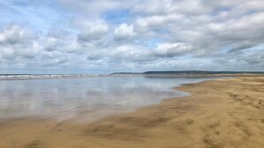 A beach with wide sandy shores and a calm sea under a partly cloudy sky. - 2 Bed in Bideford (oc-62964) (Appledore)