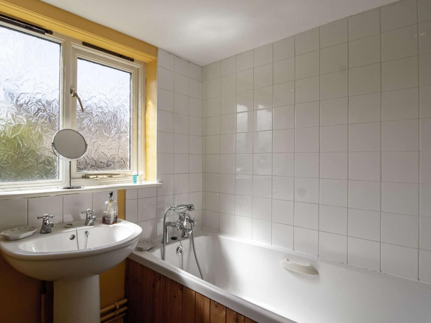 Un baño con lavabo, espejo y bañera.