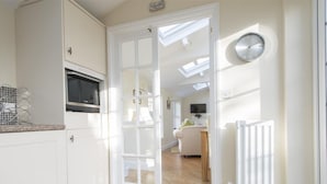 Une cuisine moderne avec des meubles blancs, un four à micro-ondes et un îlot central.